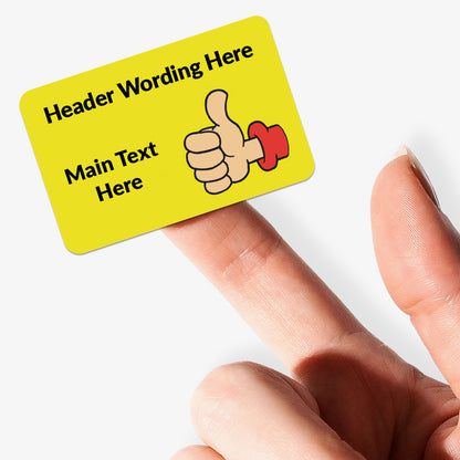 Rectangle yellow sticker with thumbs up decals and text. held by finger