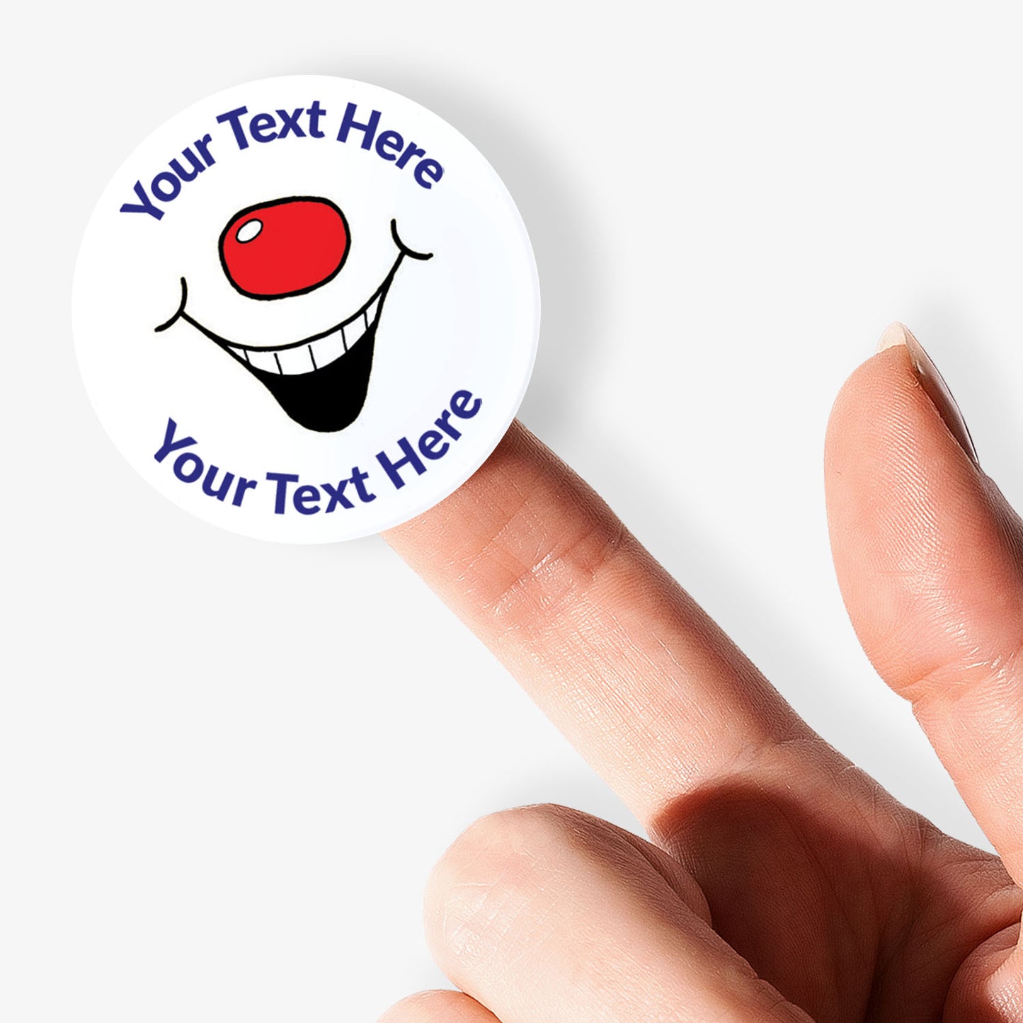 Circular sticker with smiley face design held by a finger on a white background
