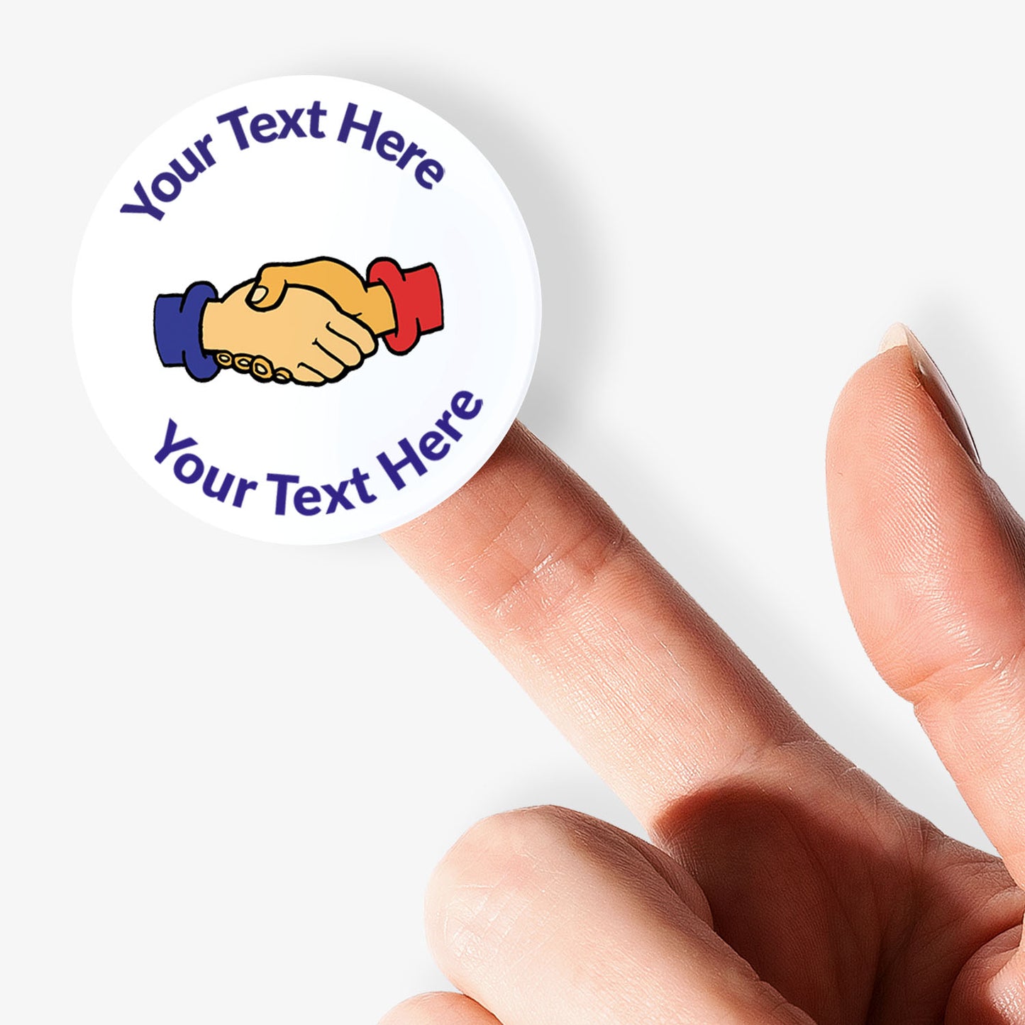 Round sticker with handshake graphic and text 'Your Text Here' held by a finger on a white background
