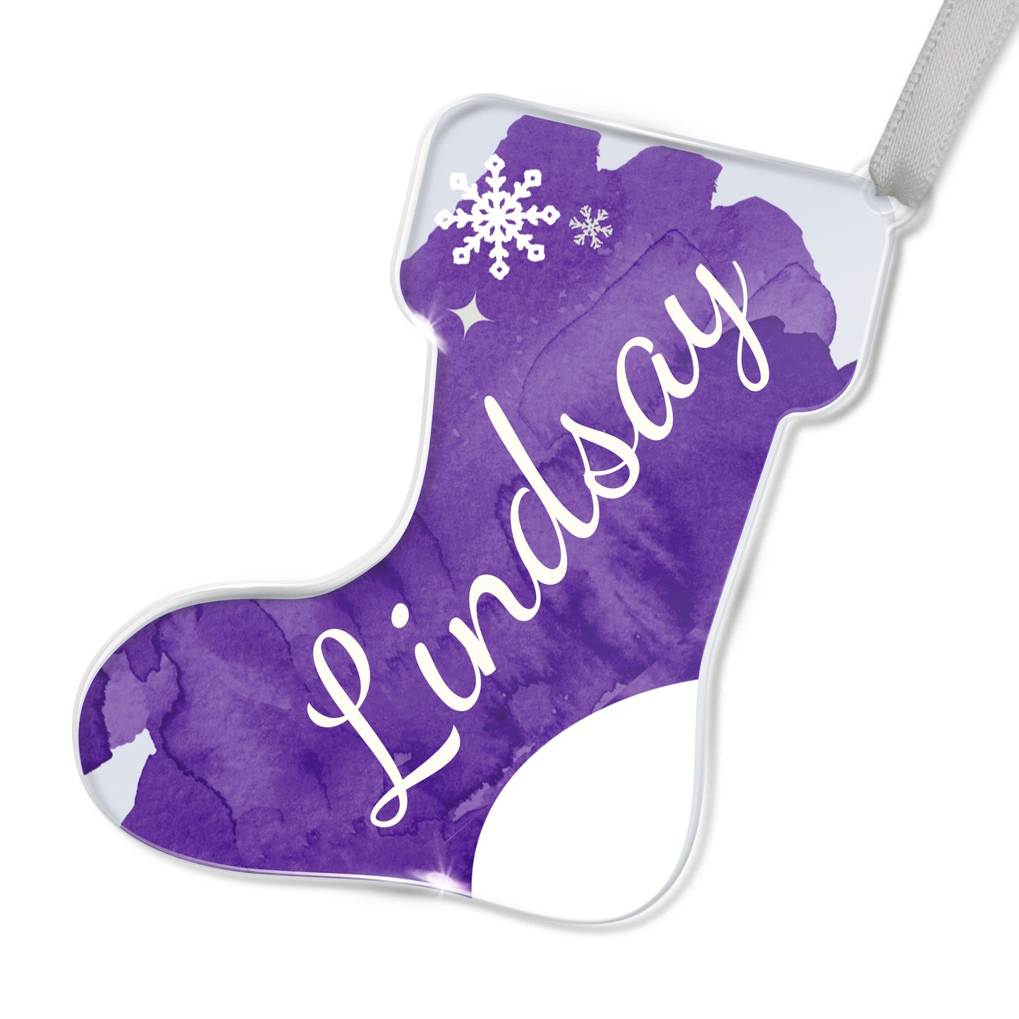 Personalised Christmas stocking-shaped acrylic decoration with the name 'Lindsay' written in white script on a purple background, featuring a snowflake design, placed on a white surface.