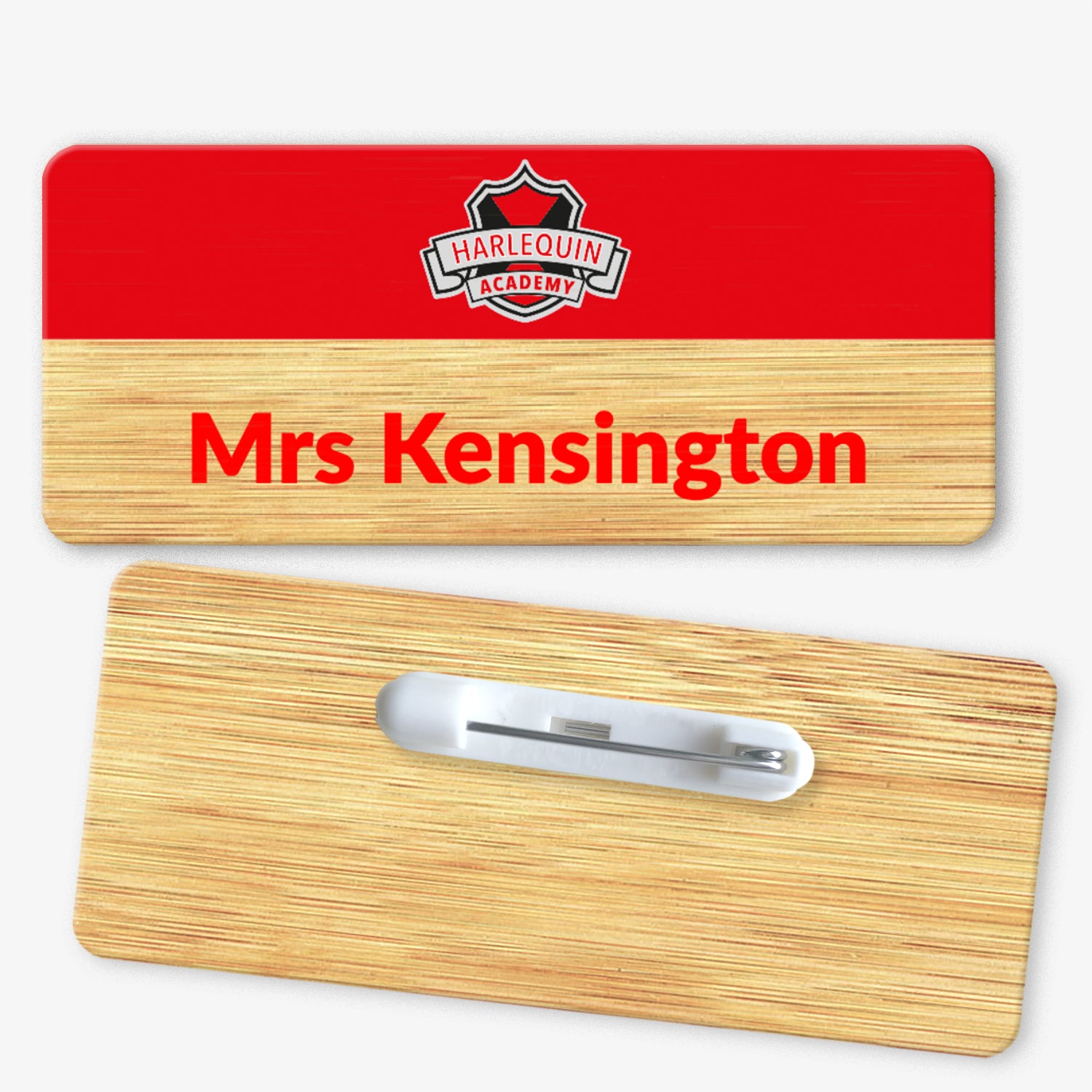 A rectangular bamboo name badge with a natural background and a red top section. The text reads 'Mrs Kensington' in bold red letters on the natural part, and there is a school logo placed centrally on the top red section. The reverse side of the badge is also shown, featuring a metal safety pin fastening for attachment.