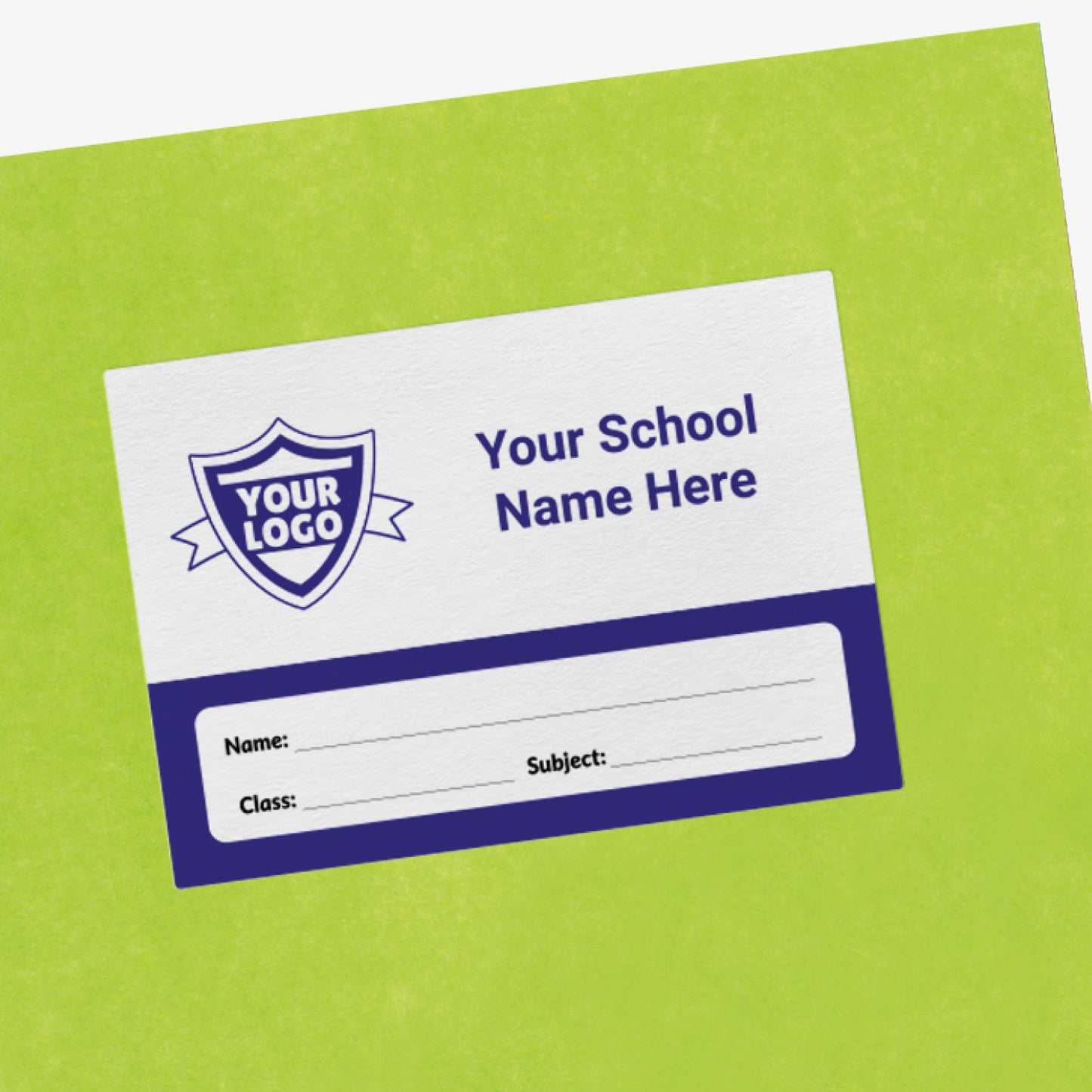 Green exercise book with a customisable white and navy label on the front. The label includes a placeholder shield icon reading 'Your Logo' and text stating 'Your School Name Here'. Below are blank lines labelled 'Name', 'Class', and 'Subject' for personalisation.