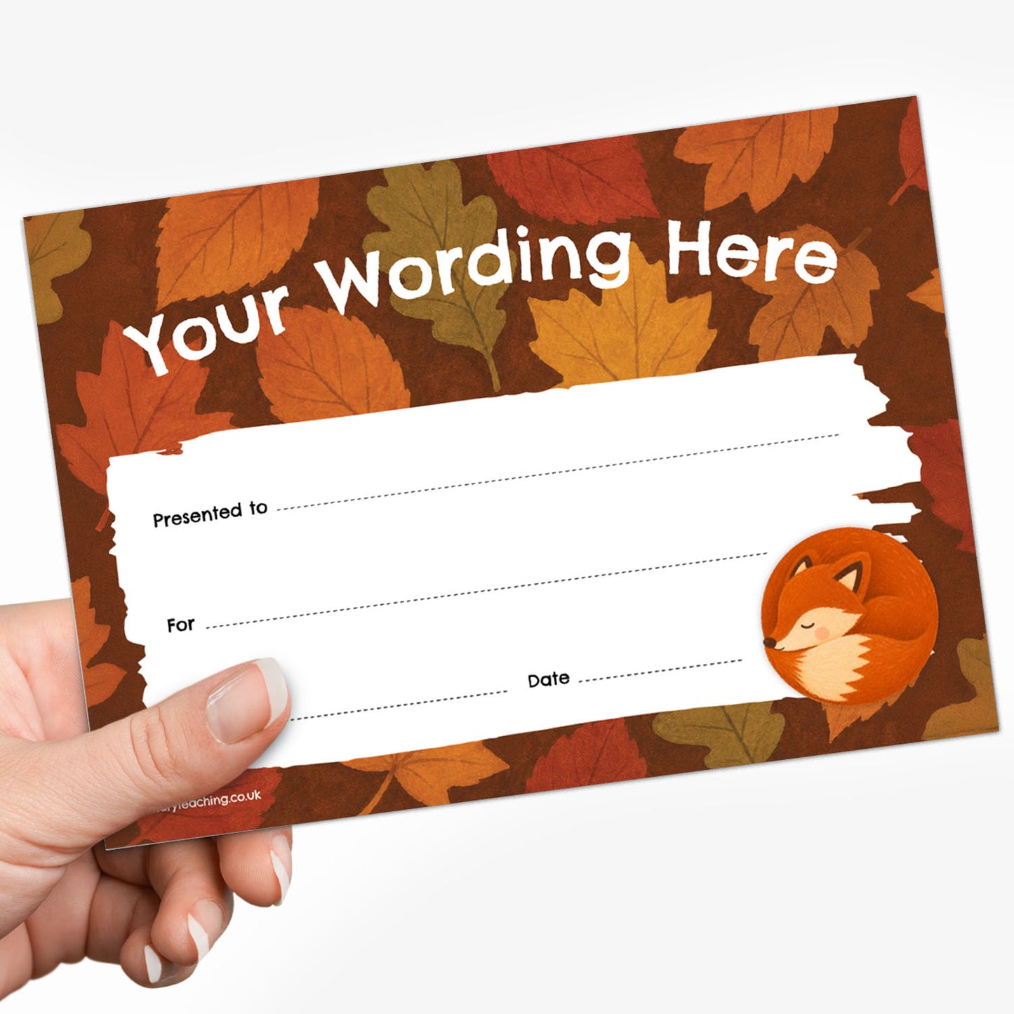 A hand holding a customisable autumn-themed writing card with a brown and orange leaf pattern, a white writing area, and a small fox illustration.