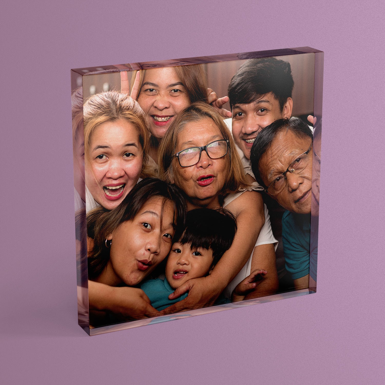 A square acrylic photo block featuring a photo of a generational family photo.  The block has a glossy, freestanding design ideal for display.