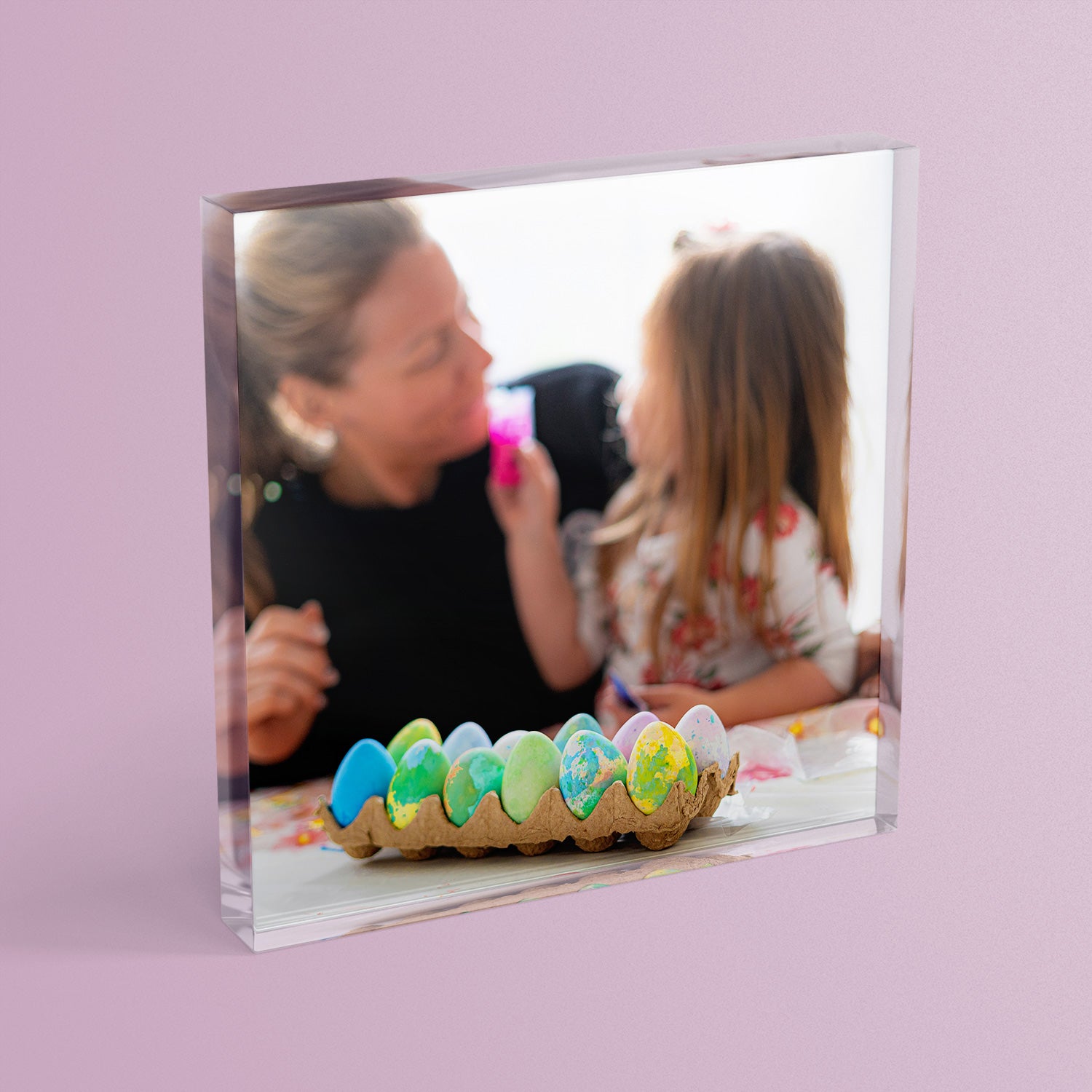 A square acrylic photo block featuring a photo of a mother and daughter painting eggs.  The block has a glossy, freestanding design ideal for display.