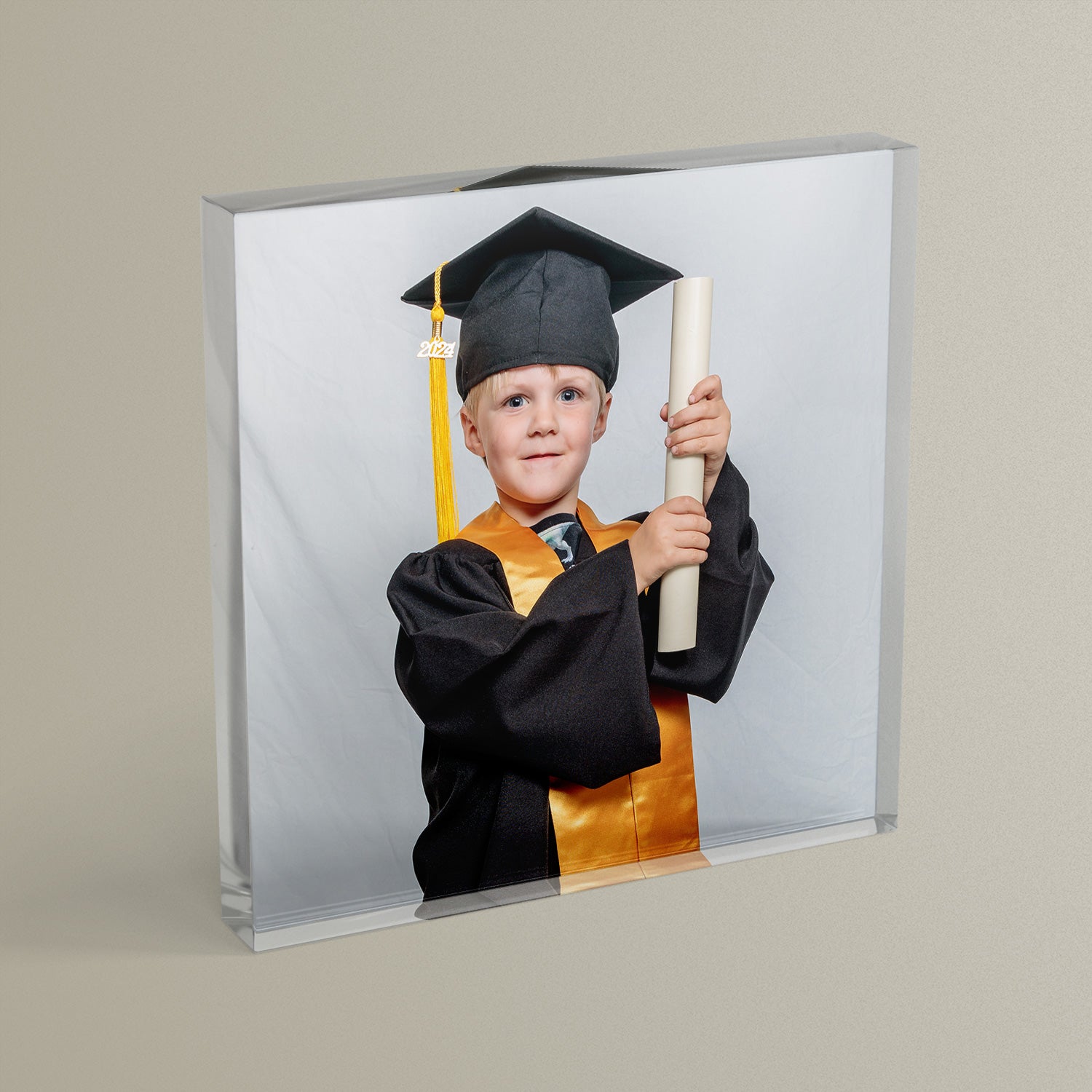 A square acrylic photo block featuring a photo of a child graduating nursery.  The block has a glossy, freestanding design ideal for display.