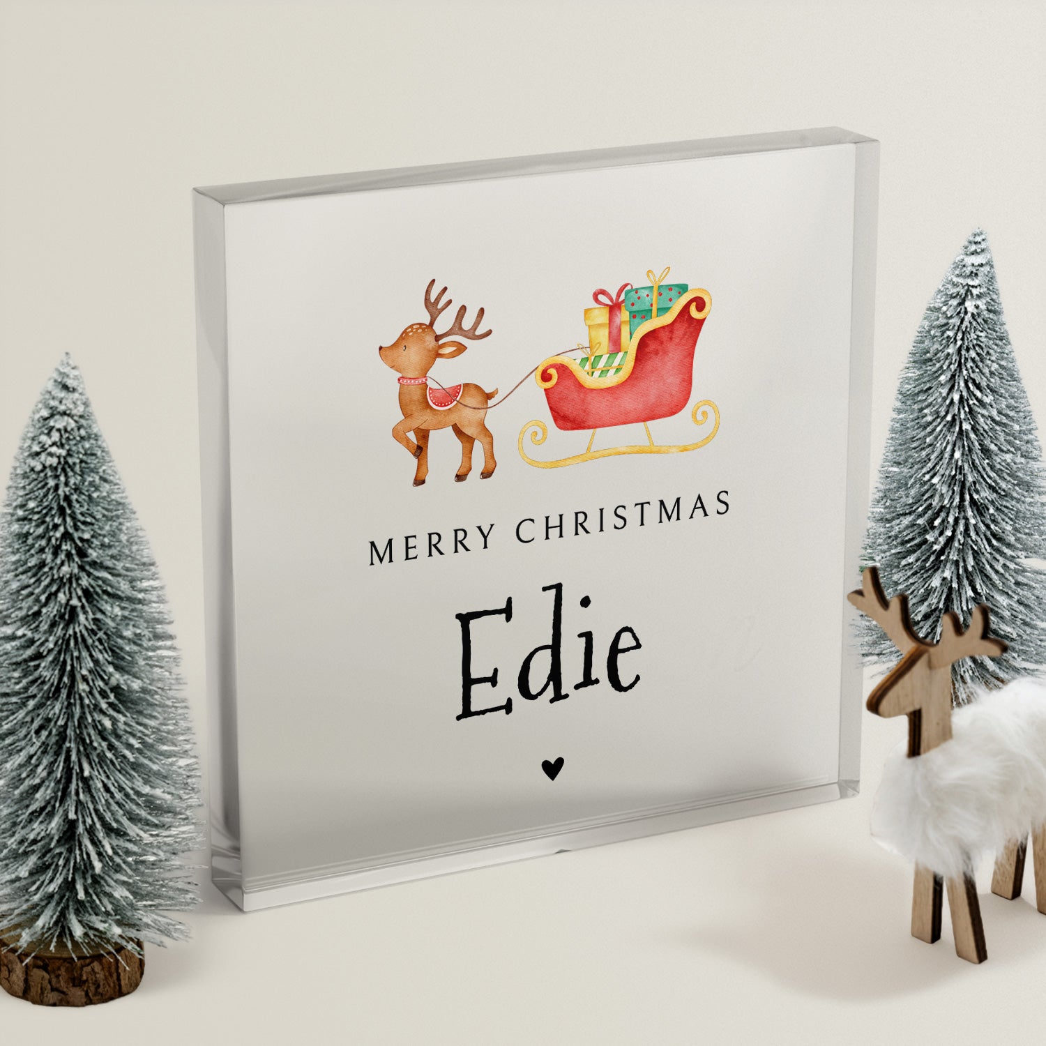 Framed Christmas-themed artwork with reindeer and sleigh, surrounded by decorative trees and deer figurines.