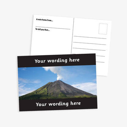 Personalised Volcano A6 Postcard –  features a striking photograph of an active volcano emitting a plume of smoke against a clear blue sky. The image is bordered by black bands at the top and bottom, where custom text can be added. The reverse side includes space for a handwritten message and address, making it perfect for use in geography lessons or as a motivational reward.