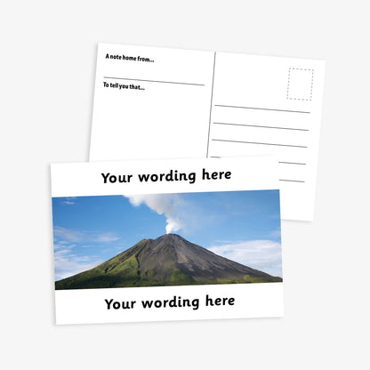 Personalised Volcano A6 Postcard –  features a striking photograph of an active volcano emitting a plume of smoke against a clear blue sky. The image is bordered by white bands at the top and bottom, where custom text can be added. The reverse side includes space for a handwritten message and address, making it perfect for use in geography lessons or as a motivational reward.