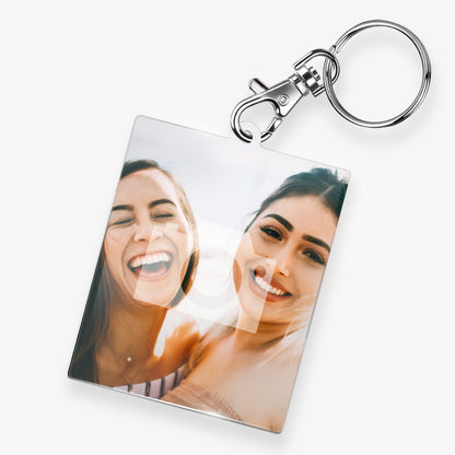 A personalised keyring featuring a rectangular photo frame design with a metal keychain and clasp. The photo shows a 2 smiling friends. 