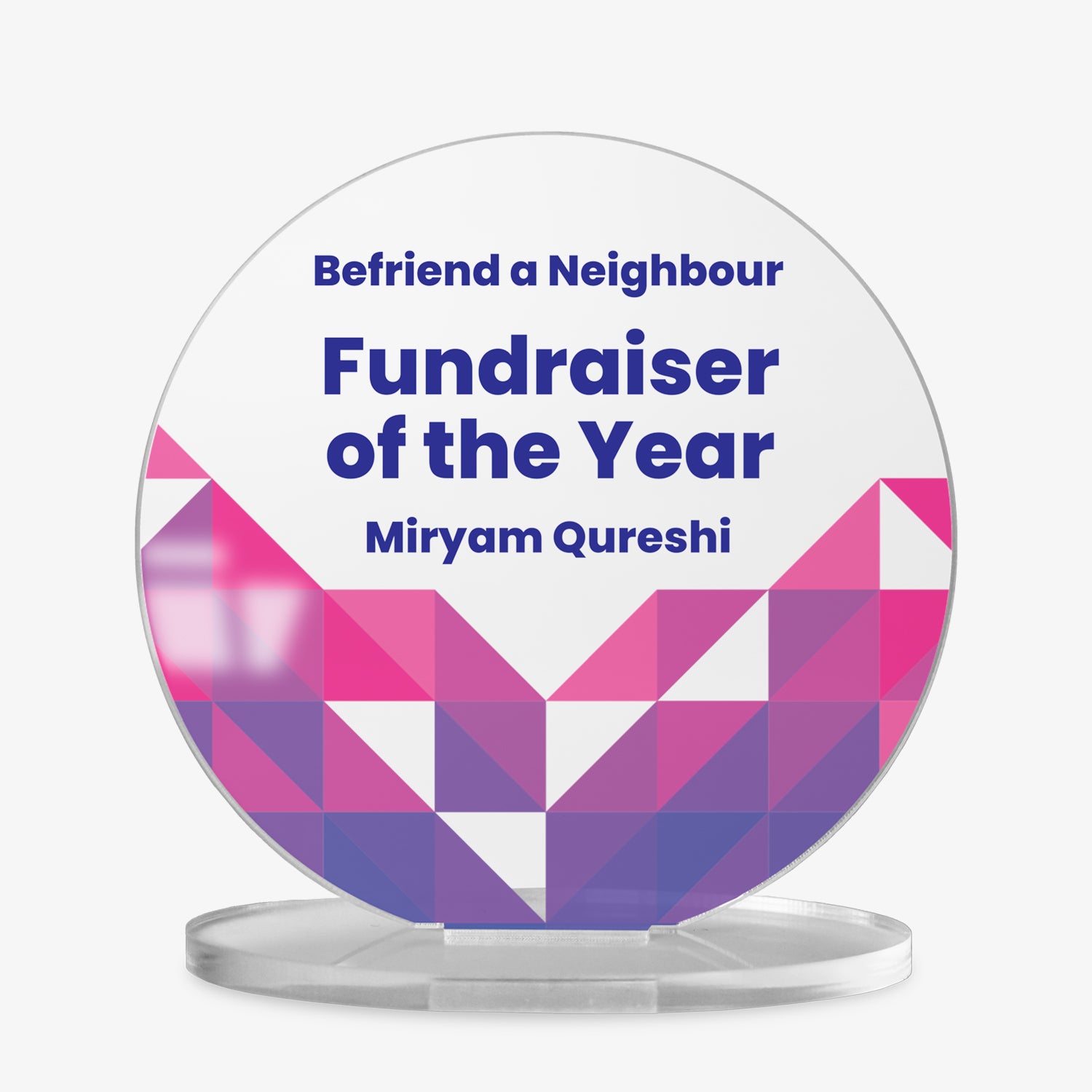 A round acrylic display plaque on a clear base. The design features three lines of customisable placeholder text reading 'Your Text Here' in bold blue font. The lower half is decorated with a vibrant geometric pattern made of colourful triangles in varying shades of purple, arranged in a symmetrical chevron shape.