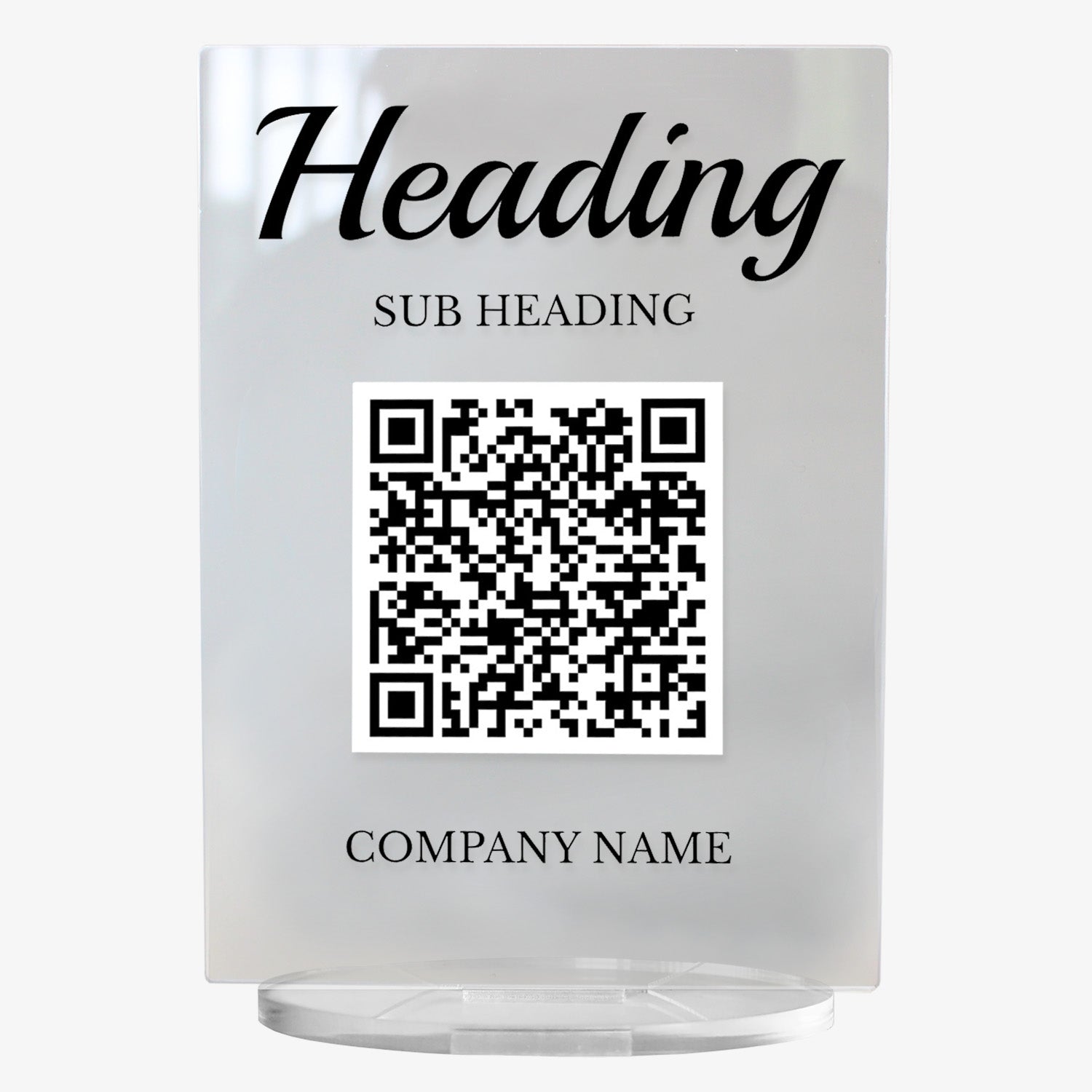 A clear acrylic sign with bold black text at the top reading 'HEADING'. Below, it another placeholder 'SUB HEADING'. A large black and white QR code is centrally displayed, and the placeholder 'COMPANY NAME' appears at the bottom. The sign stands upright on a circular clear base.