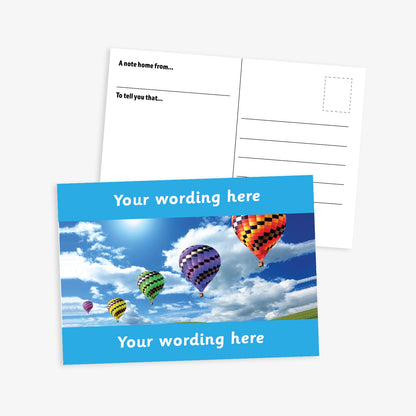 Personalised A6 Hot Air Balloon Postcard, featuring a dark blue border framing a sky scene with multiple colourful hot air balloons floating among clouds. The front side includes the placeholder text 'Your wording here!' in bold white letters, allowing for customisation. The reverse side displays a standard postcard layout with space for a message and address.