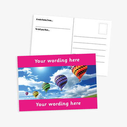 Personalised A6 Hot Air Balloon Postcard, featuring a vibrant pink border framing a sky scene with multiple colourful hot air balloons floating among clouds. The front side includes the placeholder text 'Your wording here!' in bold white letters, allowing for customisation. The reverse side displays a standard postcard layout with space for a message and address.