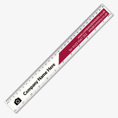 Customisable, two tone, plastic rulers with left side white with icon for image upload and 'Comapny Name Here' and the other half with a red background features the website, email and telephone number. Measurement markings in centimetres and millimetres run along the top and inches along the bottom edges of both rulers.