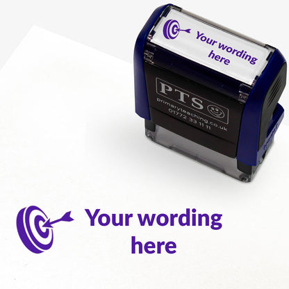 Rectangular self-inking stamper measuring 38mm by 15mm, featuring the phrase 'Your wording here' next to a target with an arrow in it in purple ink.