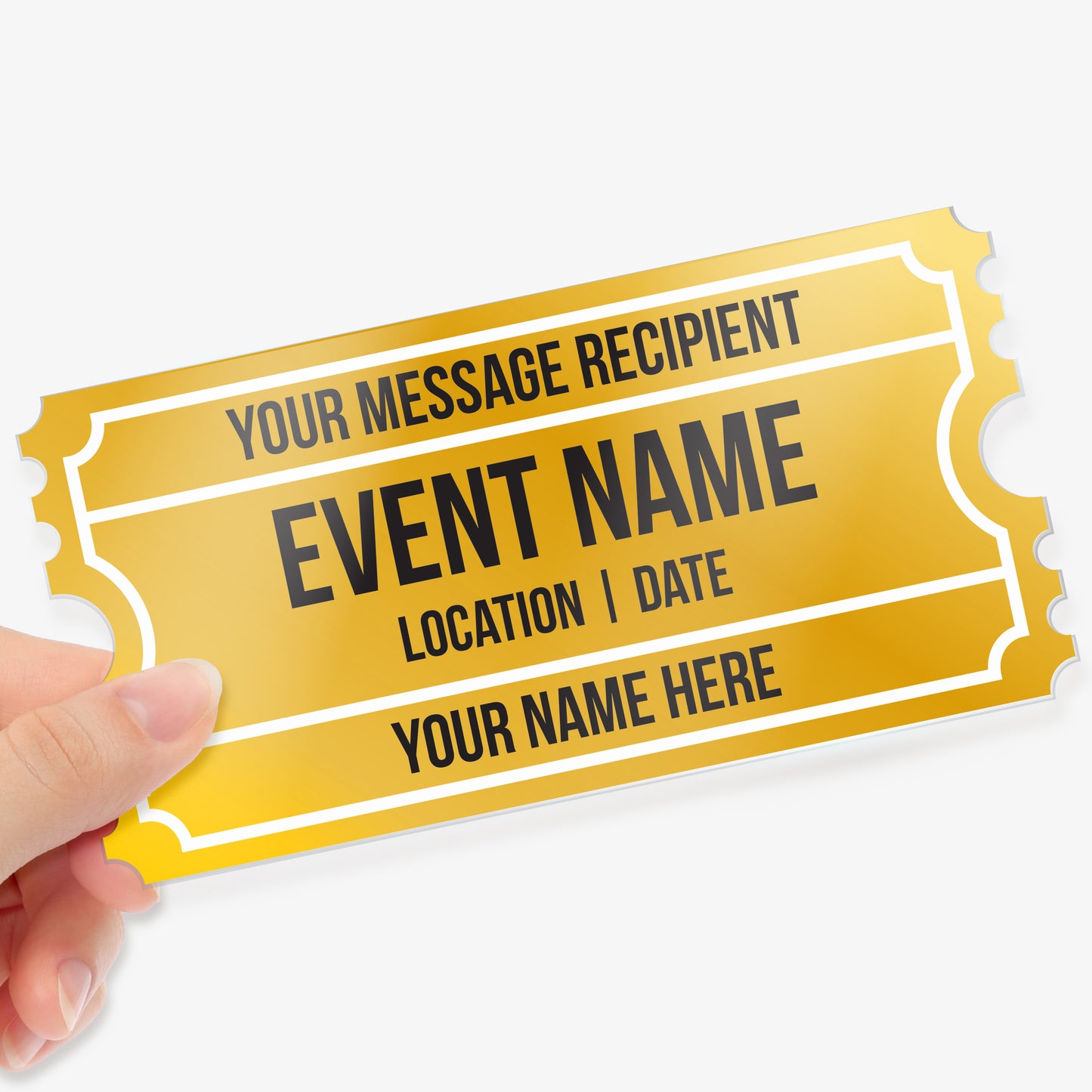 Hand holding a gold acrylic event ticket with customisable text fields in black ink, including 'Your Message Recipient', 'Event Name', 'Location | Date', and 'Your Name Here', designed with a classic ticket border style.