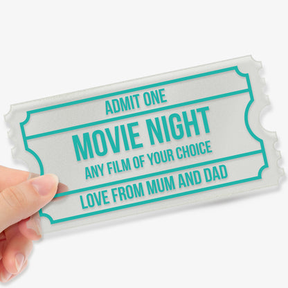 Hand holding a frosted acrylic event ticket with customisable text fields and font in cyan completed to say, including 'ADMIT ONE', 'MOVIE NIGHT', 'ANY FILM OF YOUR CHOICE', and 'LOVE FROM MUM AND DAD', designed with a classic ticket border style.