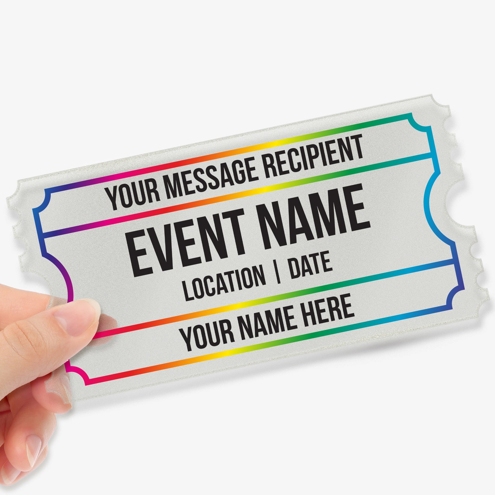 Hand holding a frosted acrylic event ticket with rainbow border lines and customisable text fields, including 'Your Message Recipient', 'Event Name', 'Location | Date', and 'Your Name Here' in bold black lettering