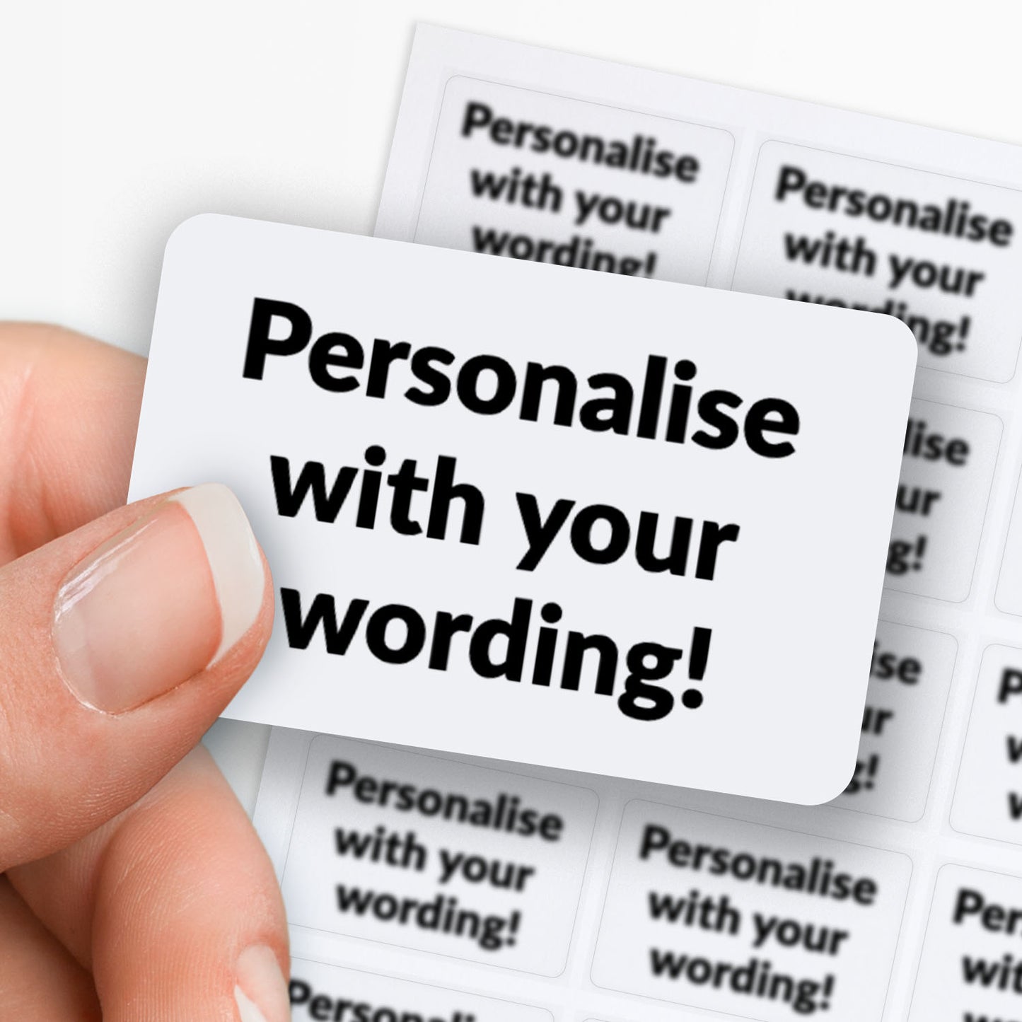 Customizable sticker with black text and white background with sheet of stickers in the background.