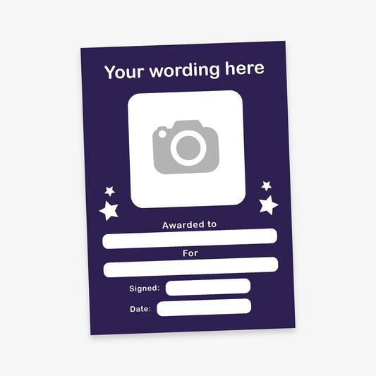 Customisable award certificate with a dark purple background and white text. Includes placeholder text 'Your wording here' at the top, a square area for an image, and blank fields labelled 'Awarded to', 'For', 'Signed', and 'Date'. Decorative stars surround the image area.