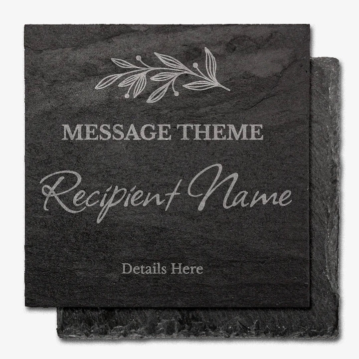 A rough edged, square black slate coaster with engraved customisable text. At the top is a delicate leaf motif. Below that, placeholder text reads 'MESSAGE THEME' in uppercase, followed by 'Recipient Name' in a large cursive font, and 'Details Here' in smaller print at the bottom.