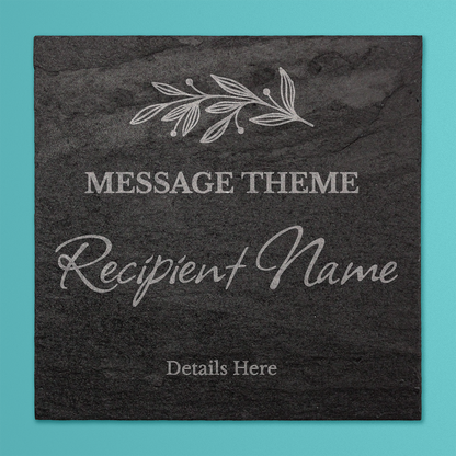 A square black slate coaster with engraved customisable text. At the top is a delicate leaf motif. Below that, placeholder text reads 'MESSAGE THEME' in uppercase, followed by 'Recipient Name' in a large cursive font, and 'Details Here' in smaller print at the bottom.