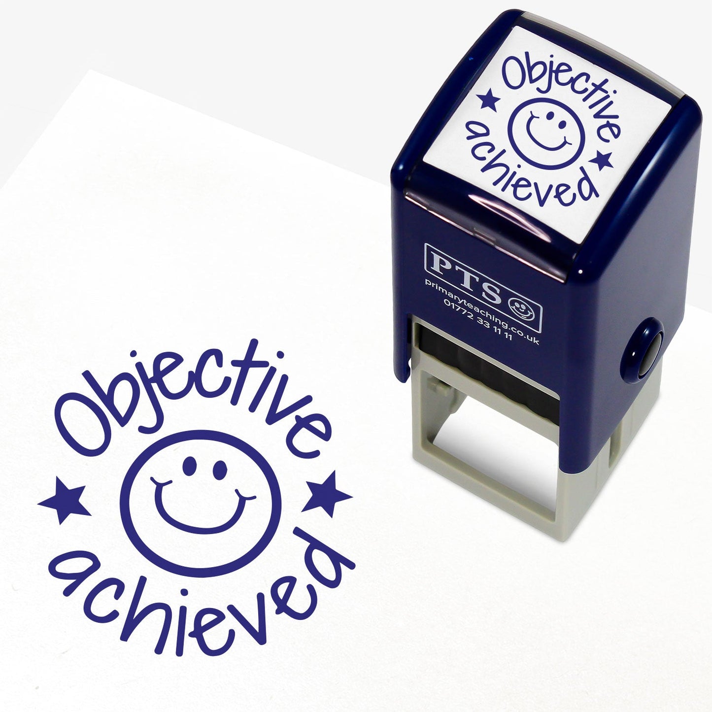 A 25mm round pre-inked teacher stamper with blue ink, featuring a central design of a smiling face with a star either side.  Above the image is the word 'Objective' and underneath the word 'achieved'.