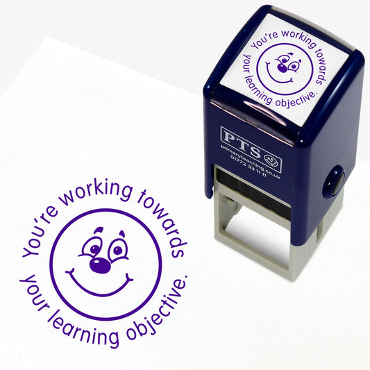 Purple 25mm pre-inked stamper featuring a smiling emoji face surrounded by the phrase 'You're working towards your learning objective'.