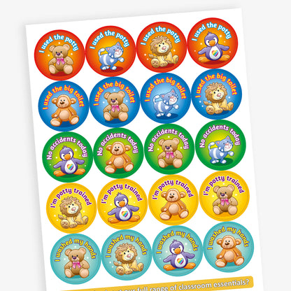 Sheet of round potty training reward stickers featuring cute cartoon teddy bears and lions. Each sticker includes a positive message such as 'I used the potty', 'I'm potty trained', 'I used the big toilet', and 'I washed my hands', displayed on bright coloured backgrounds like red, yellow, blue, and teal.