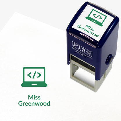 A stamper shown next to a sample stamped image on a white background. The stamp has a green outline of a laptop inside a shield shape, with placeholder text 'Miss Greenwood' on the top panel and below the stamp print.