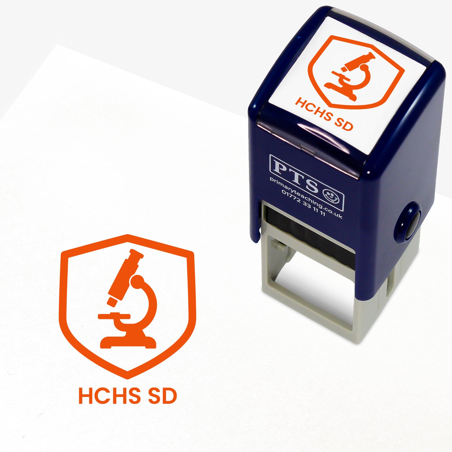 A stamper shown next to a sample stamped image on a white background. The stamp has an orange outline of a microscope inside a shield shape, with placeholder text 'HCHS SD' on the top panel and below the stamp print.