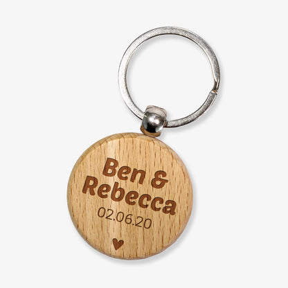 A wooden keyring with the engraved text 'Ben & Rebecca     02.06.20' along with a small star design.
