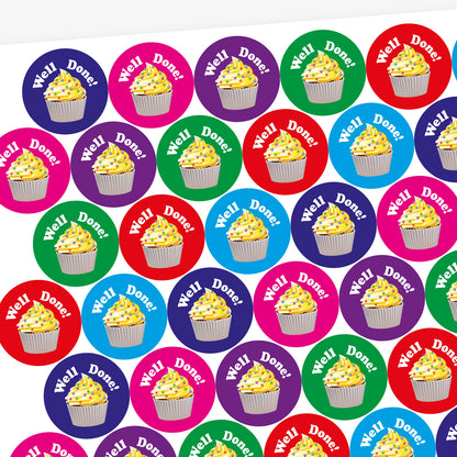 A sheet of circular, vanilla scented stickers, each with a cupcake with vanilla frosting as the main image below the phrase 'Well Done!'.  Colourful backgrounds of blue, magenta and green are shown.