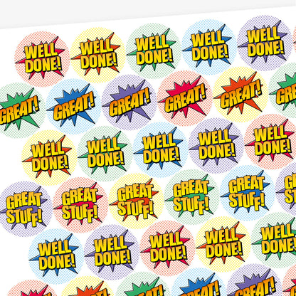 Overview of a sheet of sherbet scented colourful round stickers with comic book-style designs. Stickers feature bold text such as 'WELL DONE!' and 'GREAT!' in yellow with black outlines, set against vibrant starburst shapes in red, green, blue, and other colours.