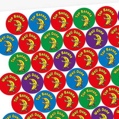 A sheet of 32mm circular stickers with banana scent.  Each featuring a smiling banana who is dancing on brightly coloured backgrounds of red, purple, blue and green.  Phrases include 'Well Done' and 'Top Banana' above the image. 