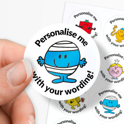 Circular sticker with a blue character and text 'Personalise me with your wording!' held by a hand.