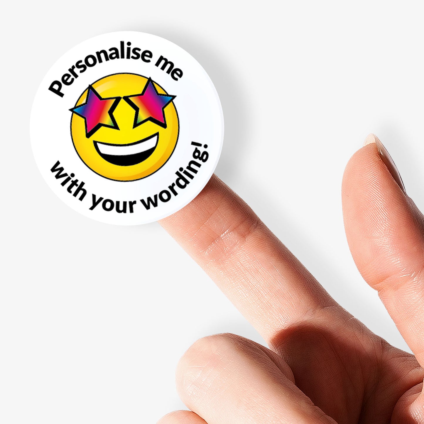 Circular sticker with smiley face and text 'Personalise me with your wording!' held by a finger on a white background