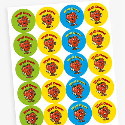 Sheet of strawberry scented, colourful round reward stickers featuring a smiling cartoon strawberry character giving a thumbs up. Each sticker has the text 'Well Done' at the top and comes in green, yellow, red, and blue backgrounds.