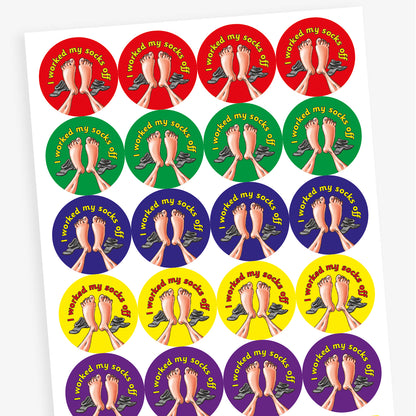 A sheet of circular stickers with clean linen scent.  Each featuring a a pair of feet with socks to the side on brightly coloured backgrounds of red, purple, yellow, blue and green.  Phrase above the image is 'I worked my socks off'