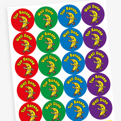 An overview of a sheet of 32mm circular stickers with banana scent.  Each featuring a smiling banana who is dancing on brightly coloured backgrounds of red, purple, blue and green.  Phrases include 'Well Done' and 'Top Banana' above the image. 