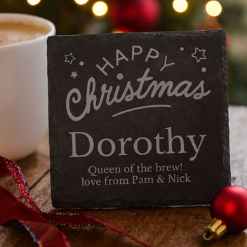 Personalized Christmas slate with 'Happy Christmas Dorothy' text, next to a mug and festive decorations.