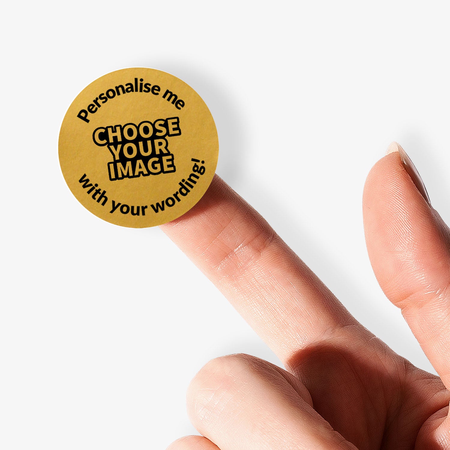 Gold circular sticker with text on a finger against a white background