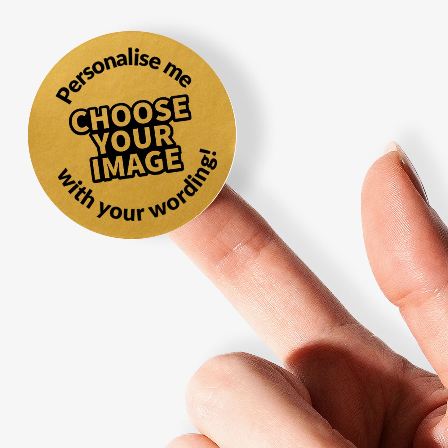 Round gold sticker with text 'Personalise me, choose your image with your wording!' held between fingers.