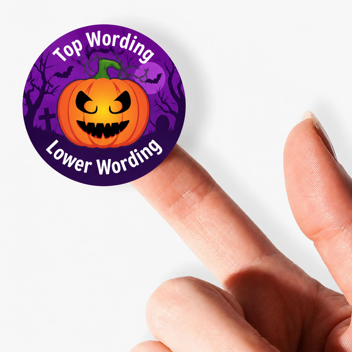 Close-up of a personalised Halloween pumpkin sticker balanced on a fingertip against a clean white background.