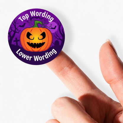 Close-up of a personalised Halloween pumpkin sticker balanced on a fingertip against a clean white background.