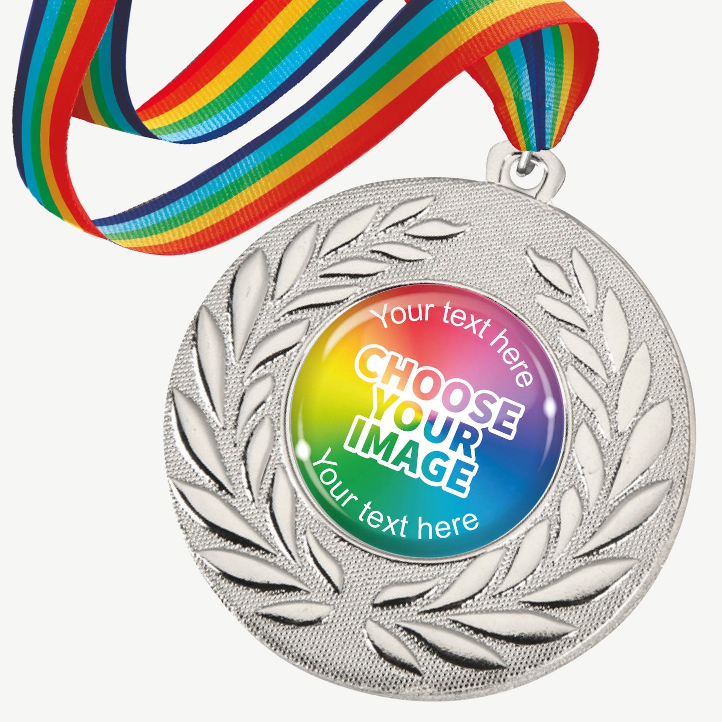 A set of ten silver-coloured metal medals, each featuring a central 25mm circular area for custom designs, encased in a clear, glossy dome; surrounded by a laurel wreath pattern and attached to a rainbow-striped ribbon; designed for personalisation with text and images, ideal for sporting events and achievements.