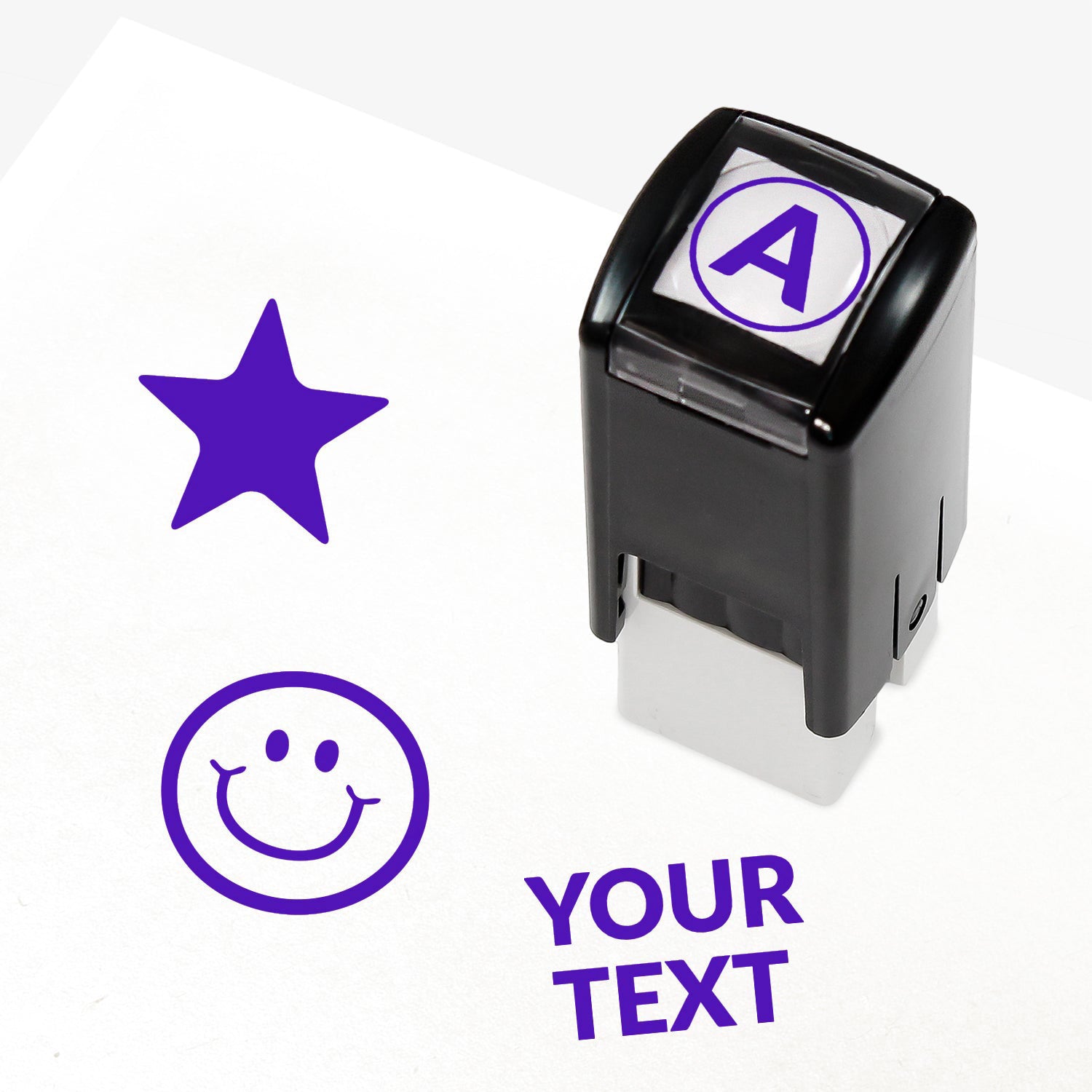 Customisable purple self-inking 10mm stamper with the placeholder text 'YOUR TEXT' in bold purple, alongside alternative options for icons such as smiling face or star, indicating space for a personalised image or message.