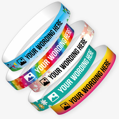 A selection of customisable wristbands in various colourful designs, each displaying the placeholder text 'YOUR WORDING HERE' alongside an icon. Background themes include stars, galaxies, planets, and rainbows. 