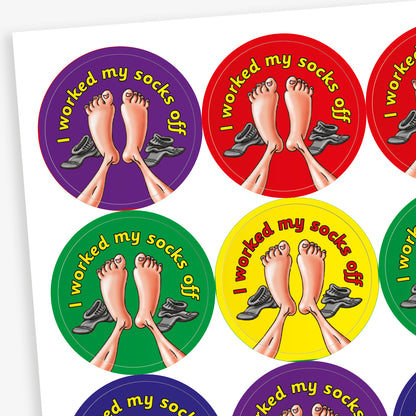 A sheet of circular stickers with clean linen scent.  Each featuring a a pair of feet with socks to the side on brightly coloured backgrounds of red, purple, yellow, blue and green.  Phrase above the image is 'I worked my socks off'